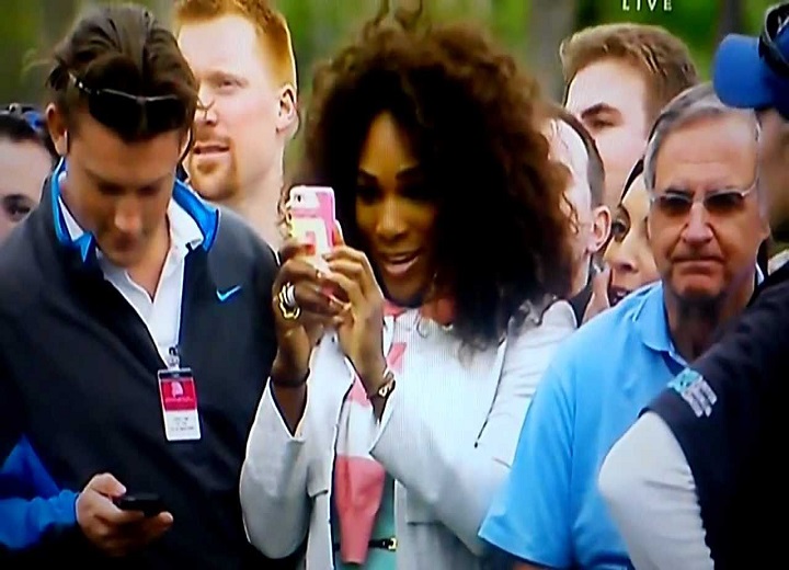 Serena Williams taking a picture of Tiger Woods