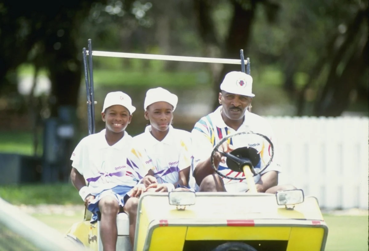 Serena Williams and her sister Venus Williams ride with their father Richard Williams at a tennis camp in Florida